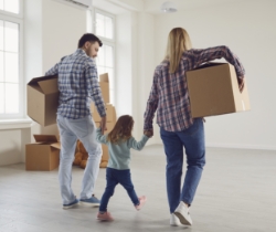A family bringing moving boxes into their new home