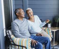 A couple laughing on their porch