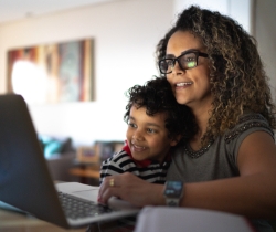 A mother and child using a laptop together 